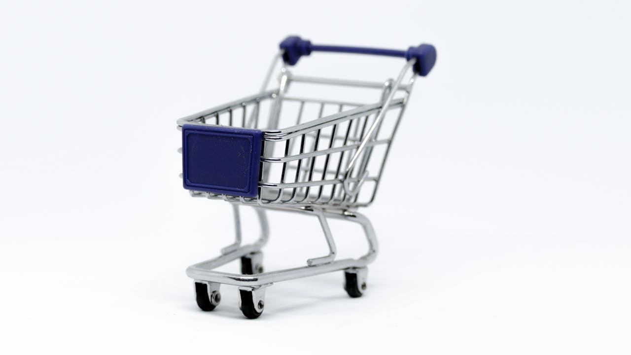 Home A modern miniature shopping cart on a clean white background, perfect for e-commerce concepts.