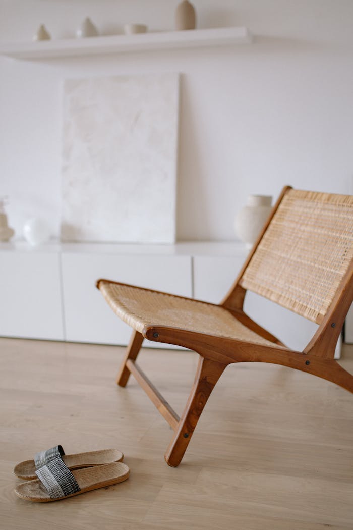 Home A stylish wooden chair with woven seat in a minimal living room setting.